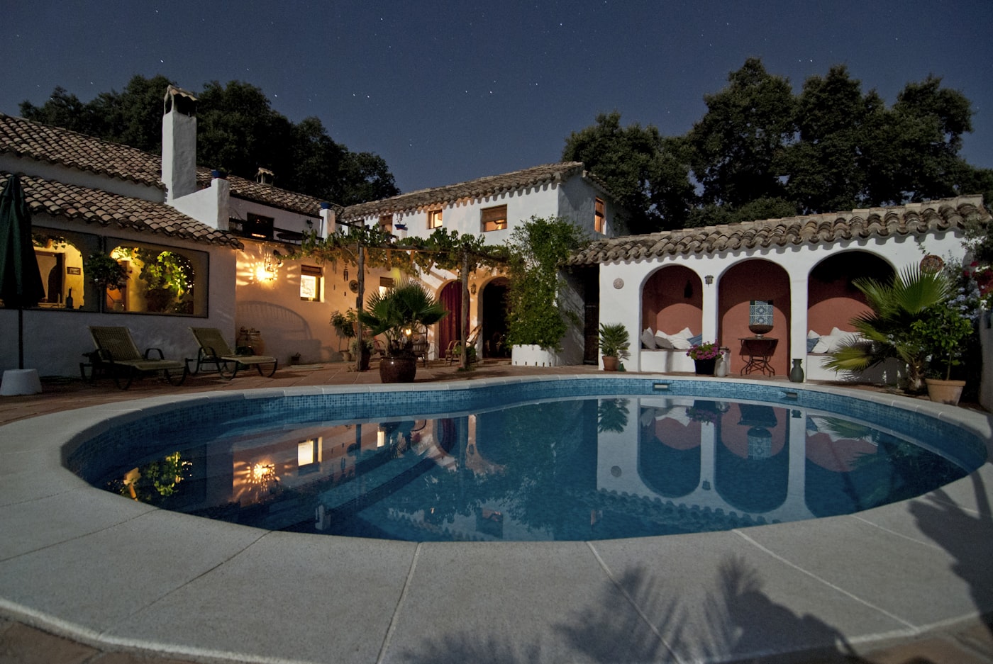 Casale ristrutturato con corte e piscina, illuminato al tramonto